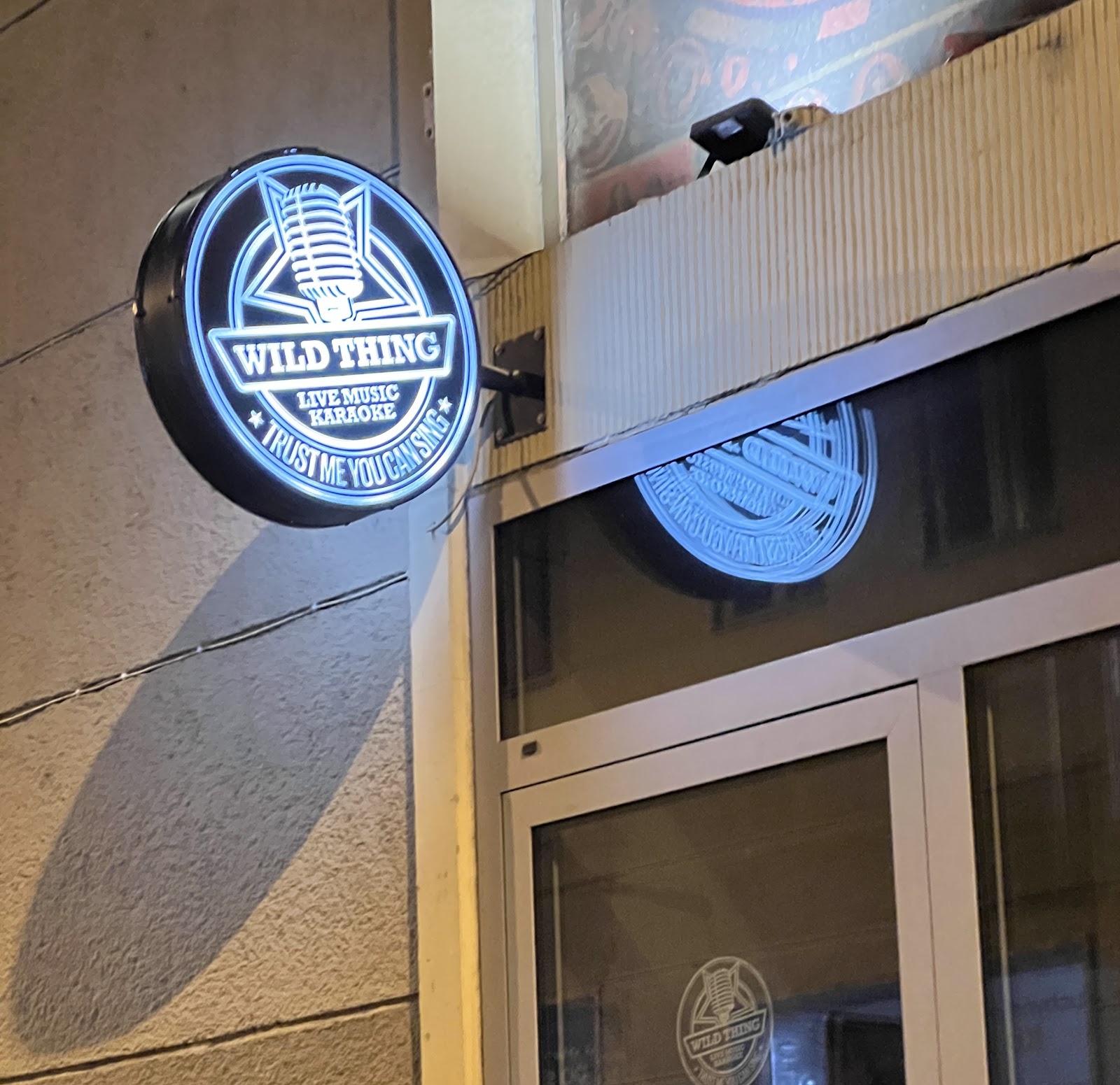 Modře zářící logo 'Wild Thing' na fasádě